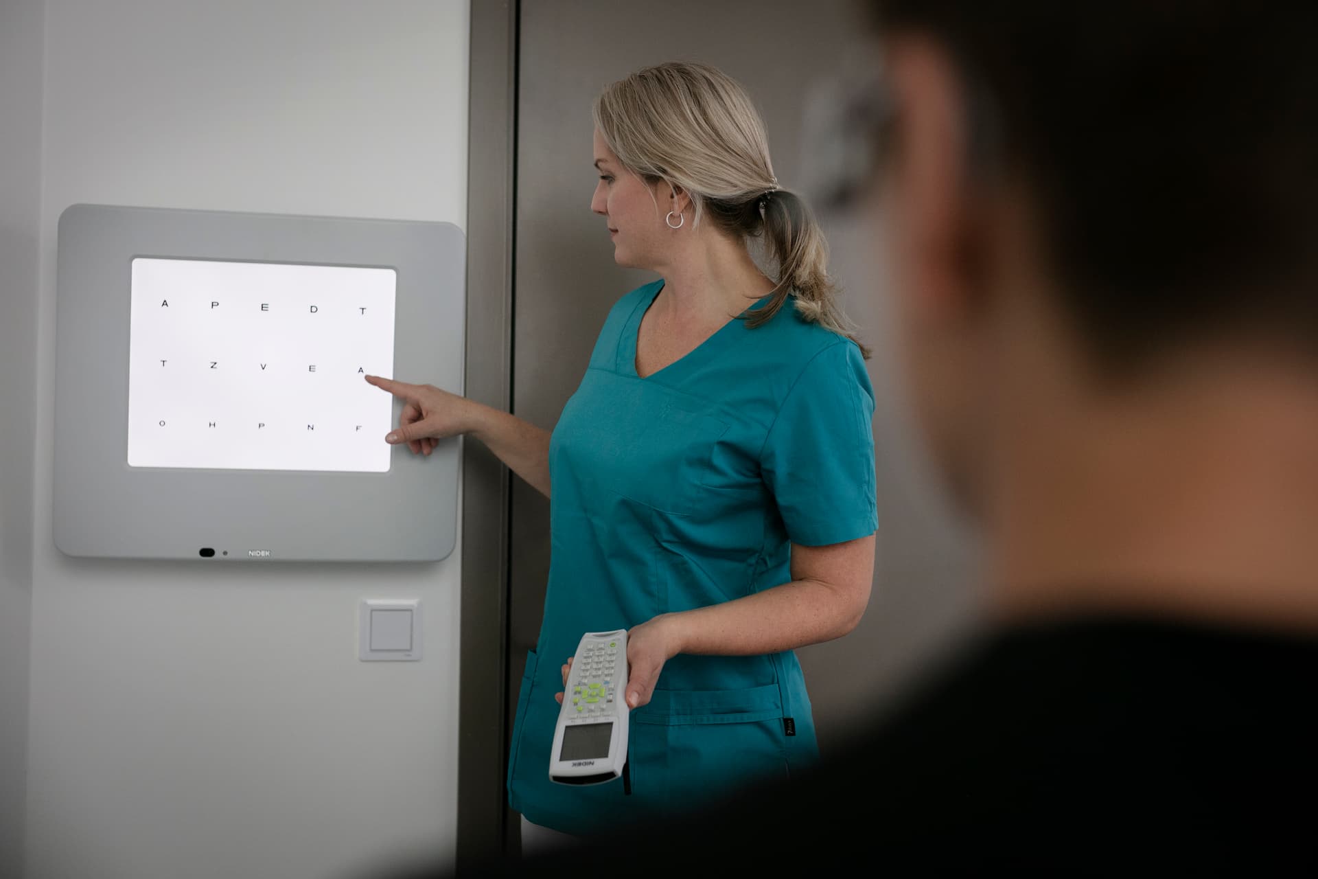 En ögonläkare undersöker efterstarr på patient.