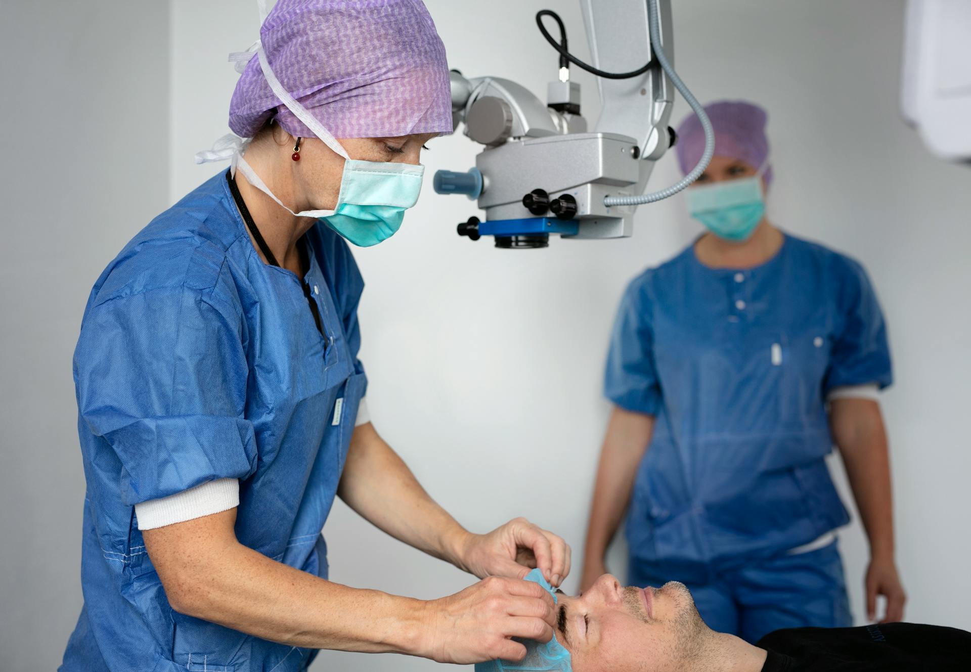 två ögonläkare genomför ett linsbyte i en operationssal